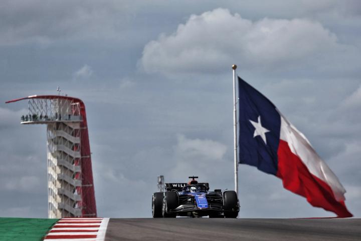 Alex Albon at the 2024 United States Grand Prix with a giant flag of Texas behind him