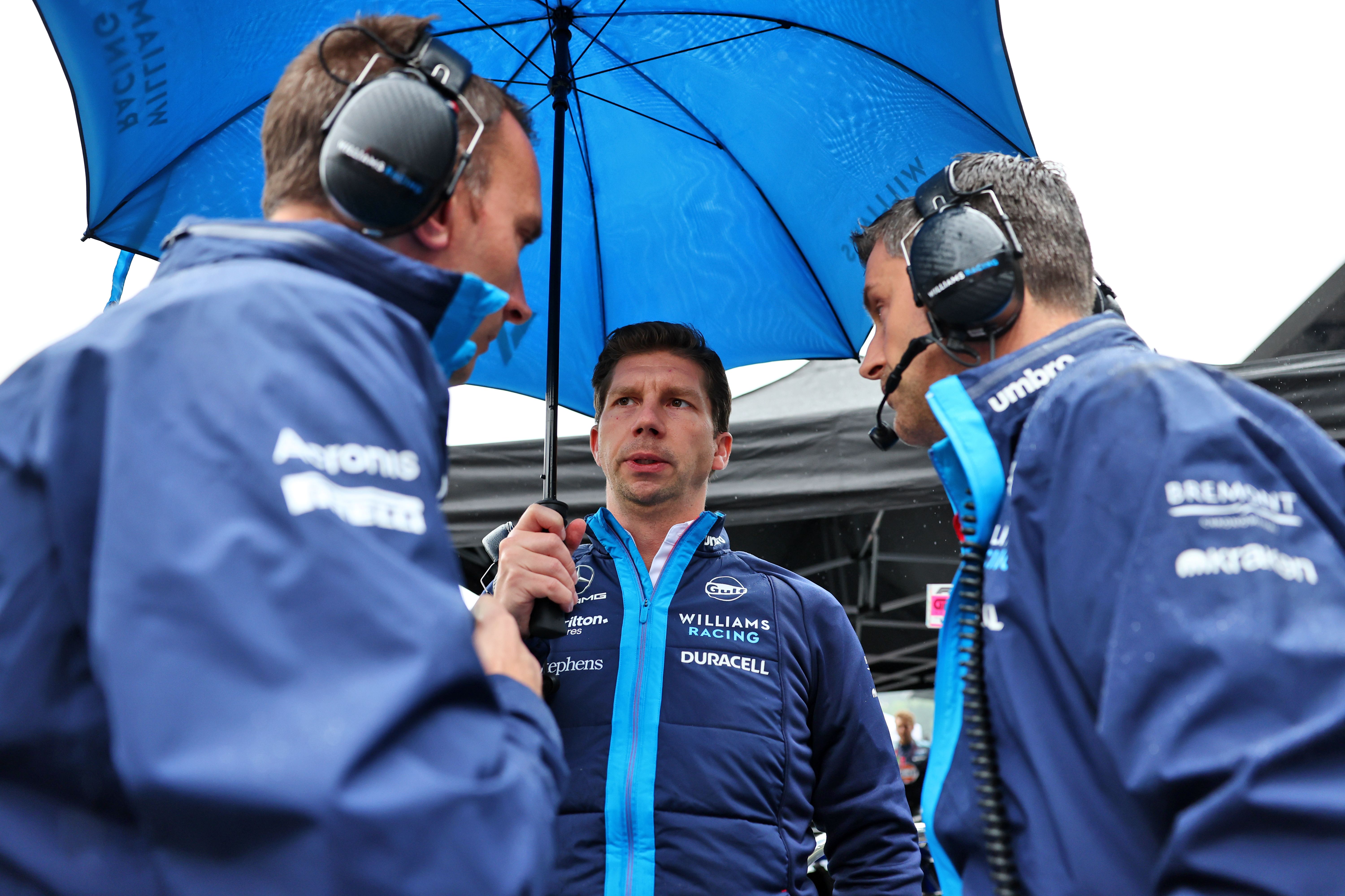 James takes shelter under an umbrella on the grid.