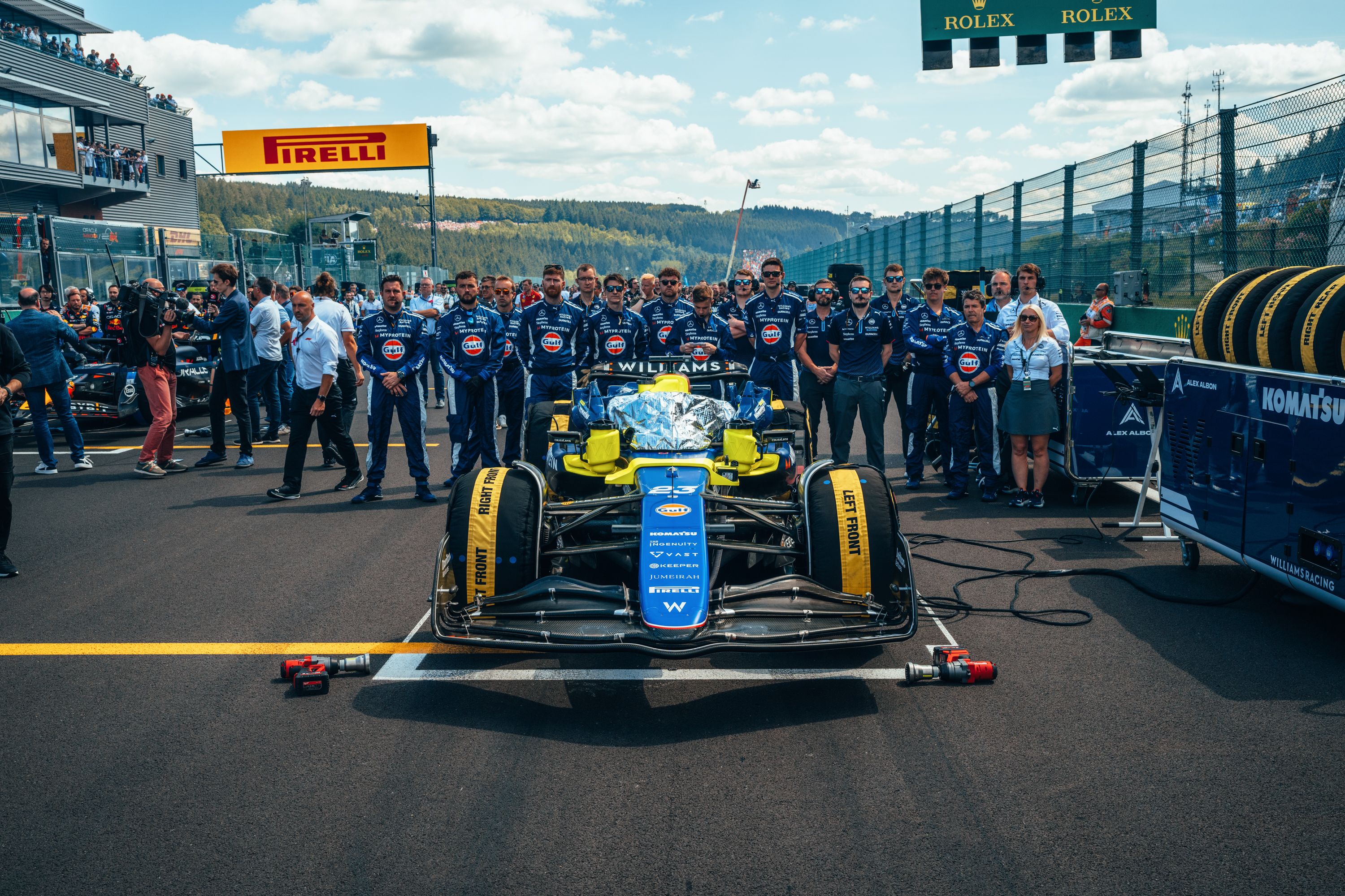The team stand behind car #23 before for the national anthem.