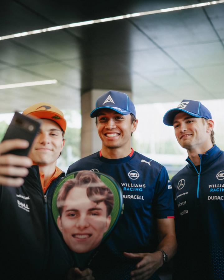 Oscar Piastri, Alex Albon and Logan Sargeant with a padel racquet with Oscar's face on