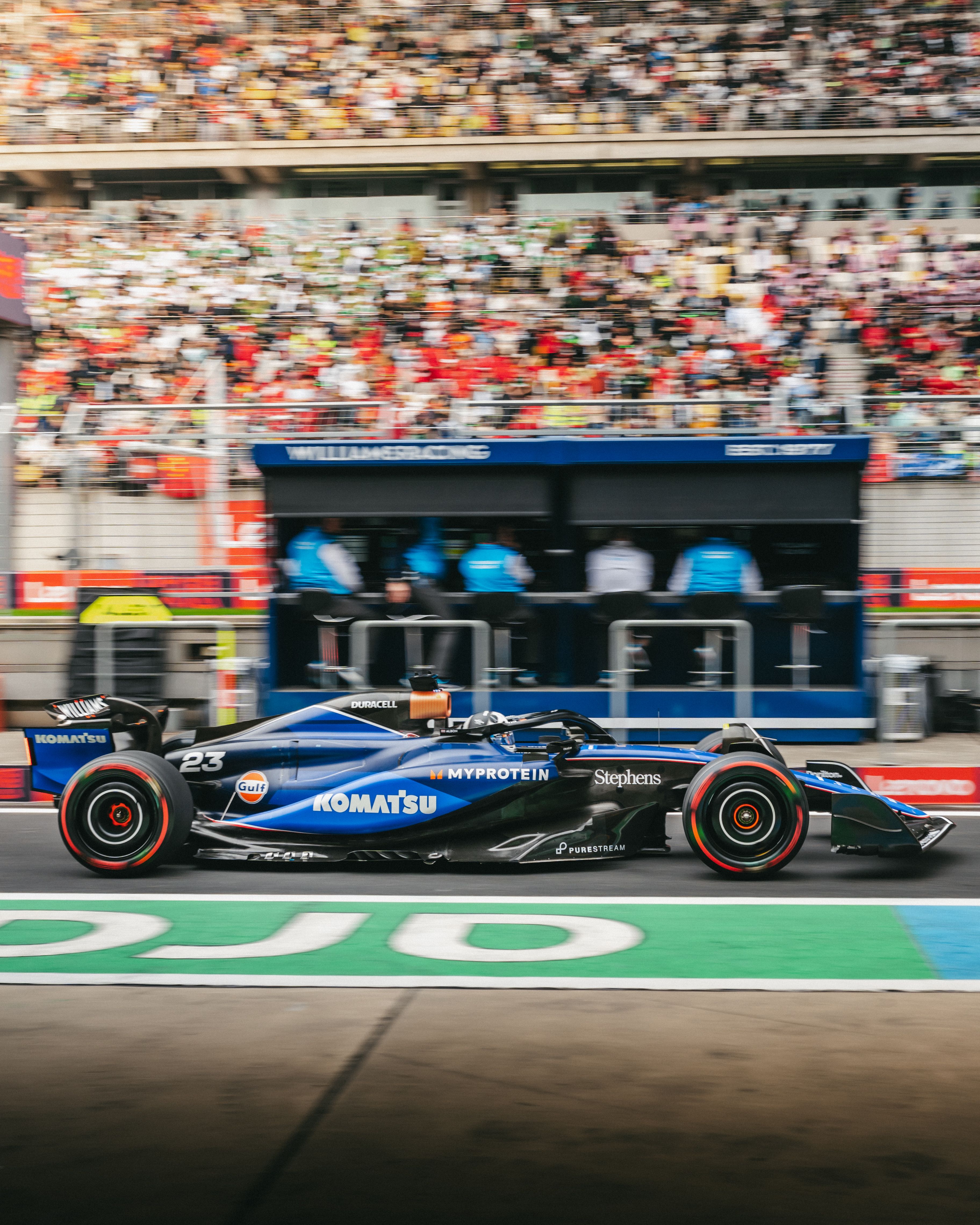 The pit wall look on as Albono drives by.