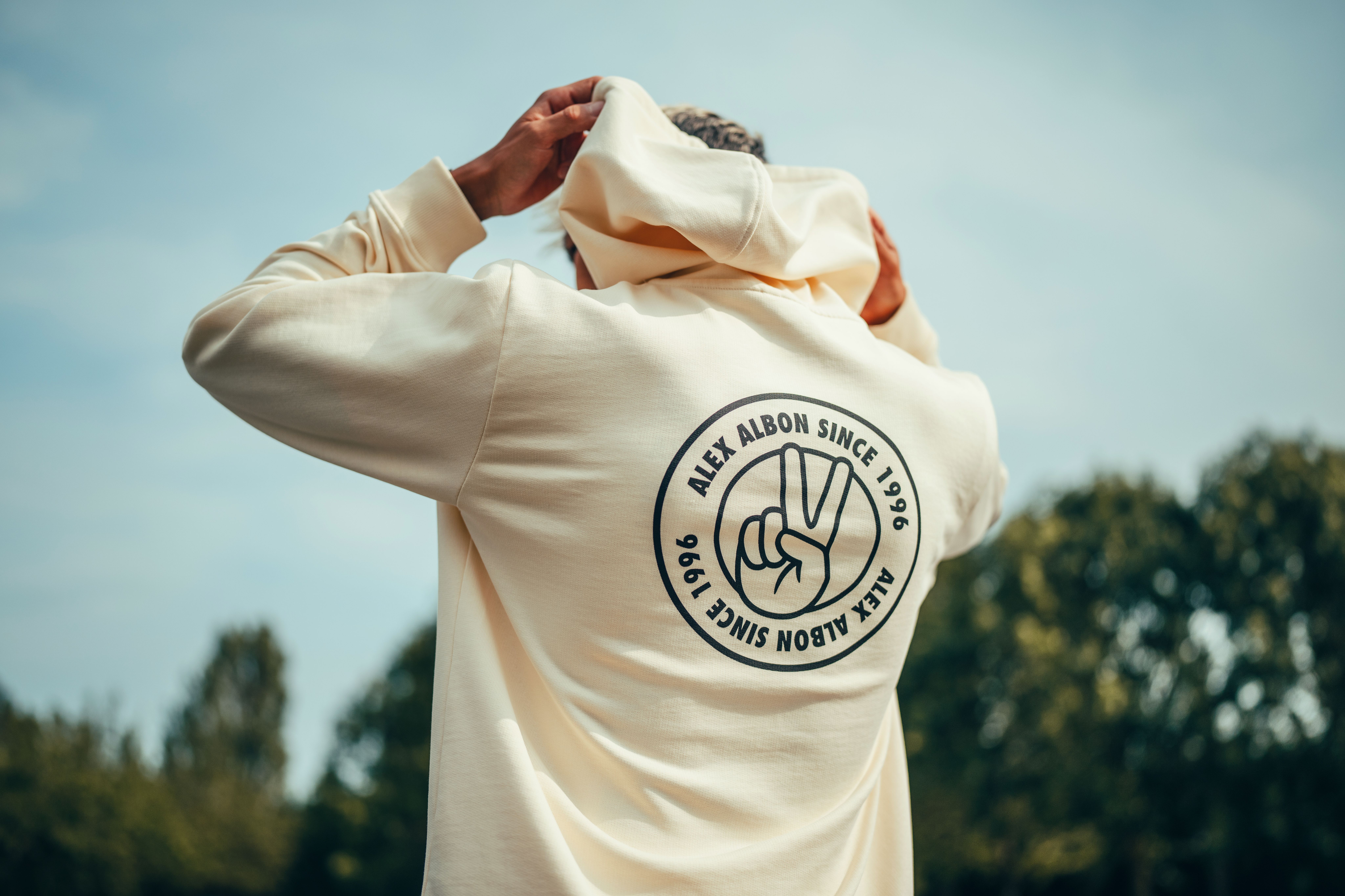 The hoodie displays his signature hand sign.