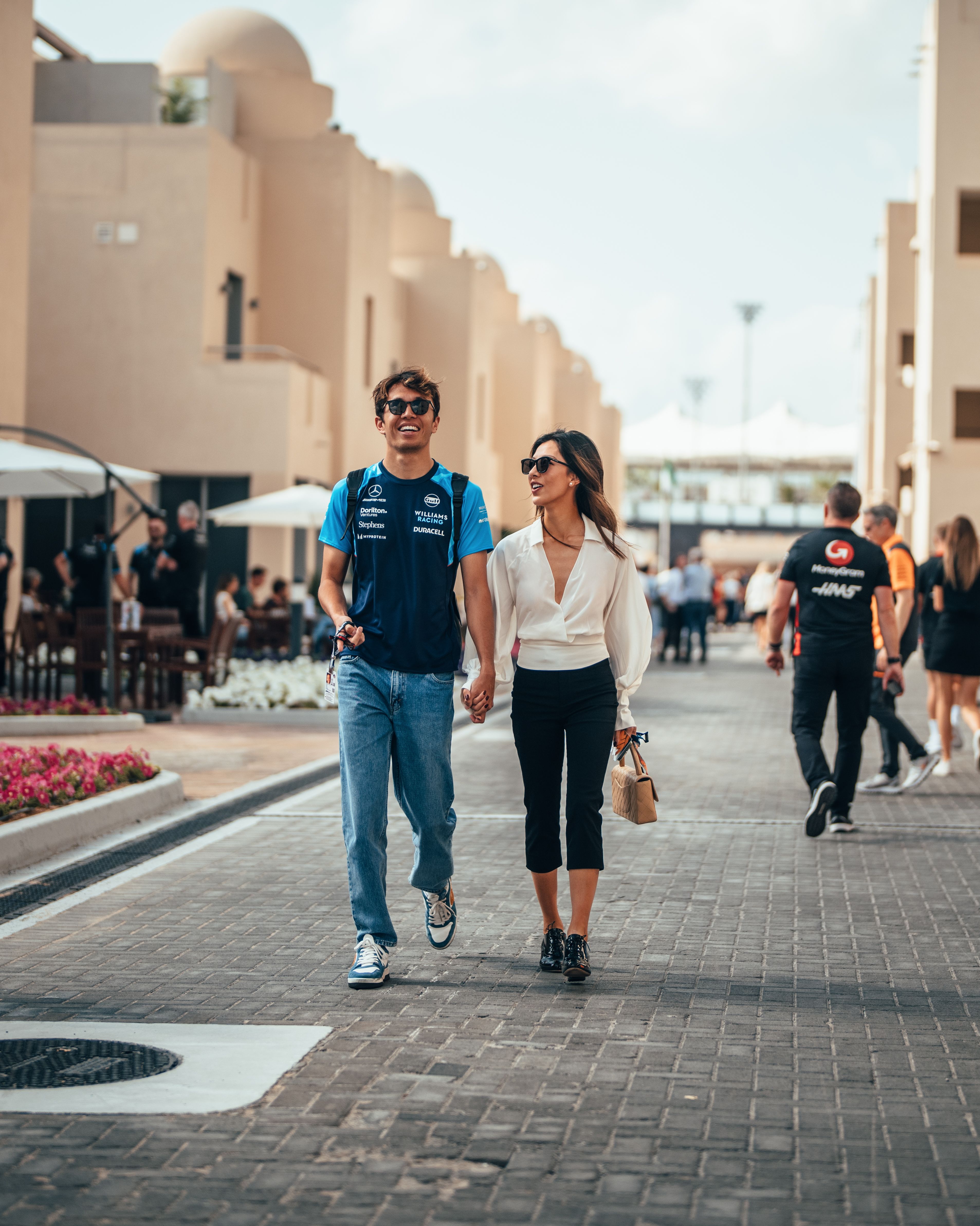 A happy Alex and Lilly walk hand in hand to the Williams Racing garage.