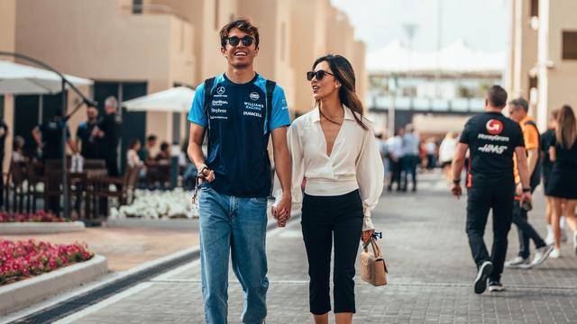 A happy Alex and Lilly walk hand in hand to the Williams Racing garage.