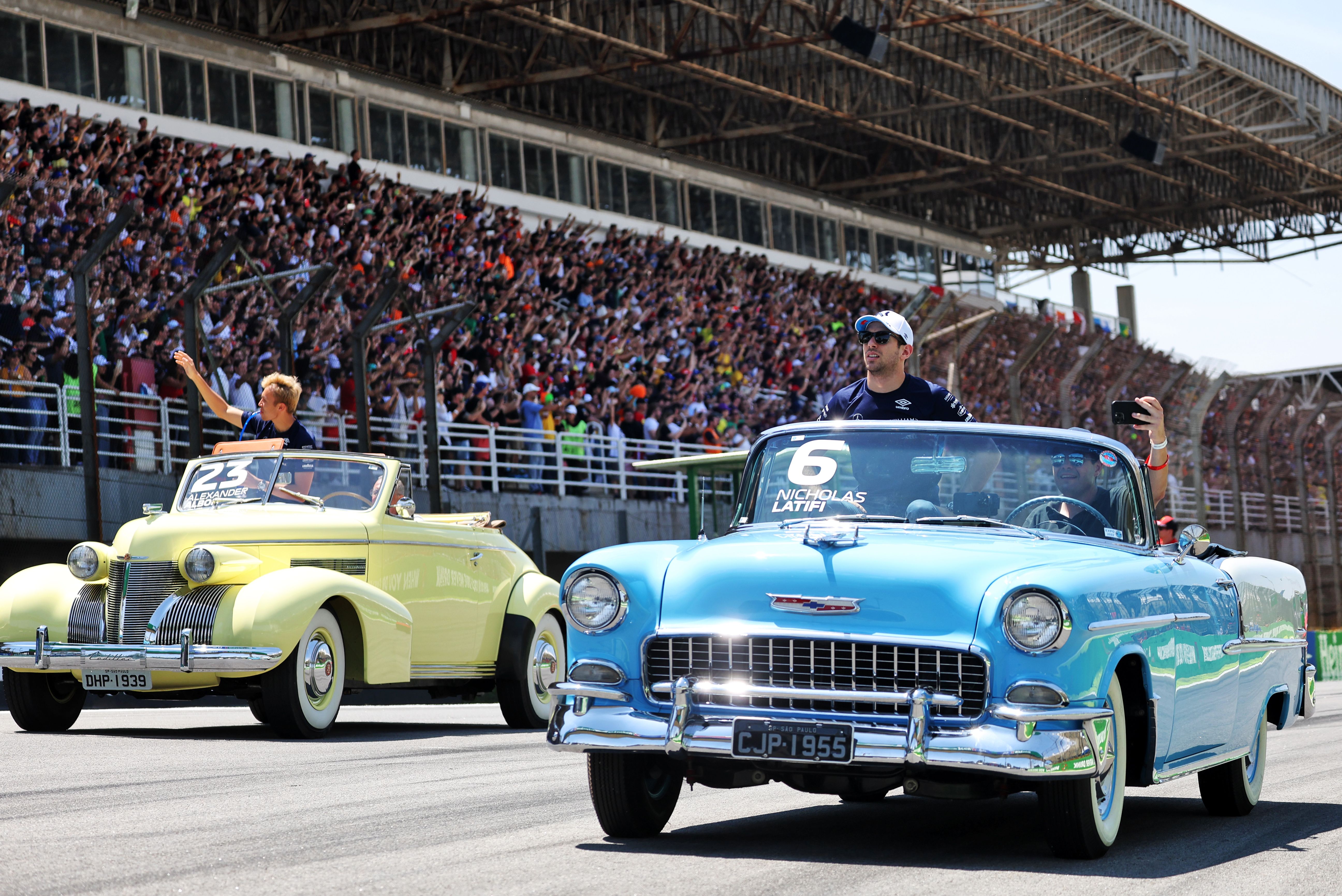 Nicky and Alex soak up the sun in these classic cars for the pre-race drivers’ parade.