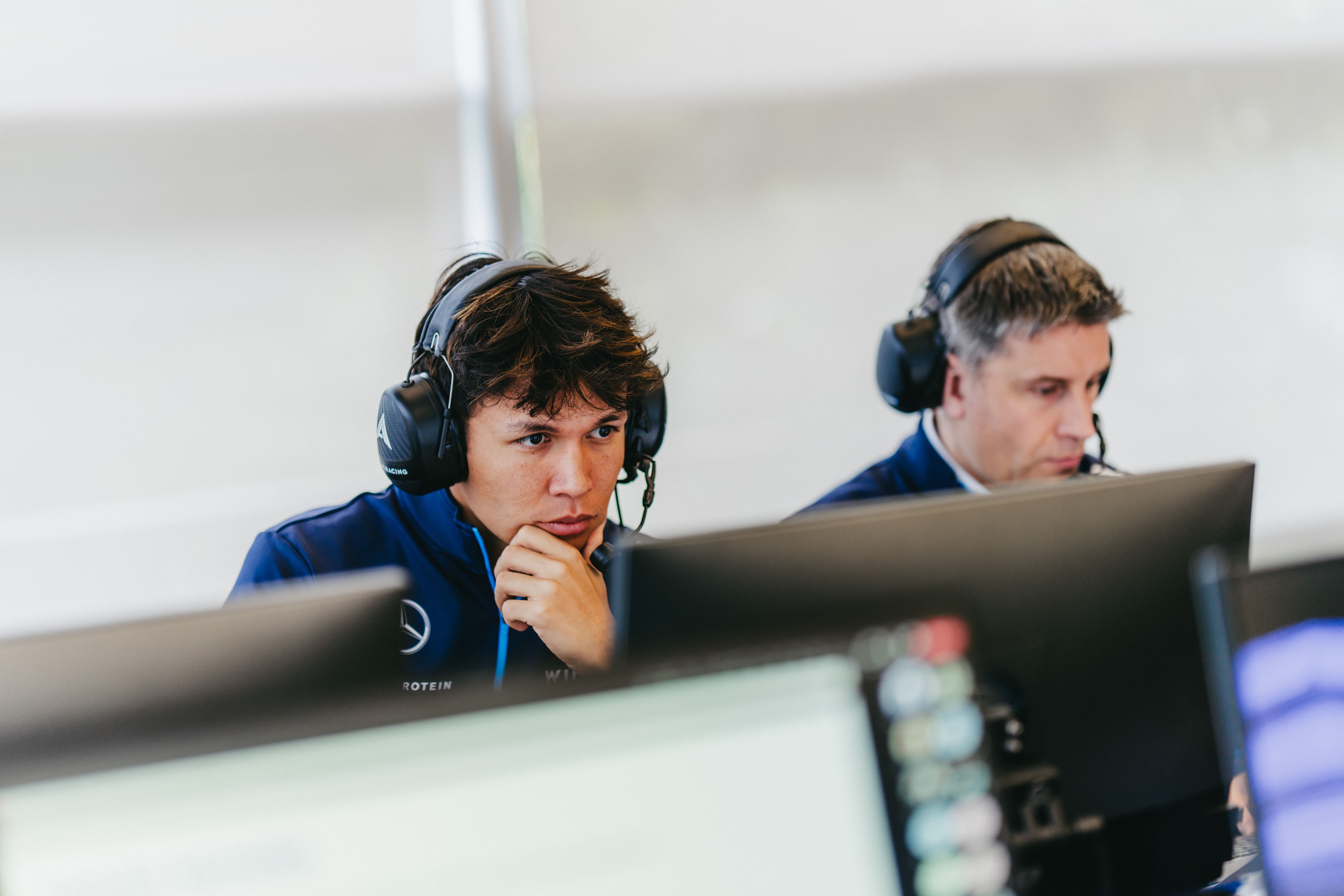 Alex checks his screen during the engineering meeting.