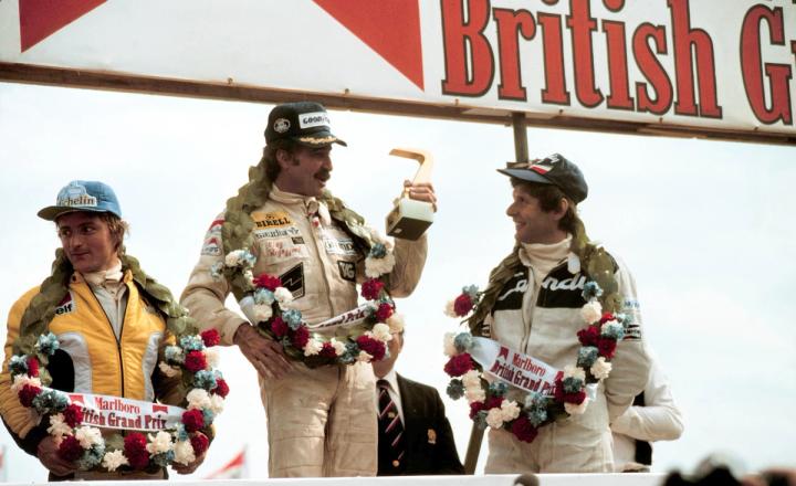 Clay Regazzoni stands on the top step at Silverstone after securing Williams Racing's first win